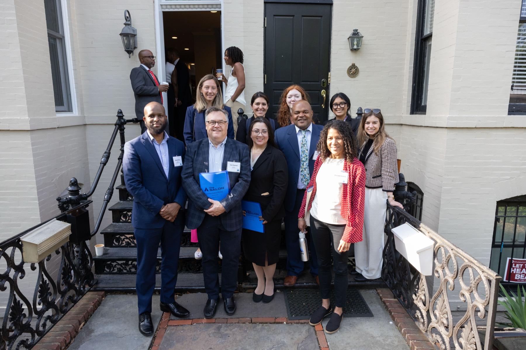 A group of professionals gathered on the steps outside a learning event